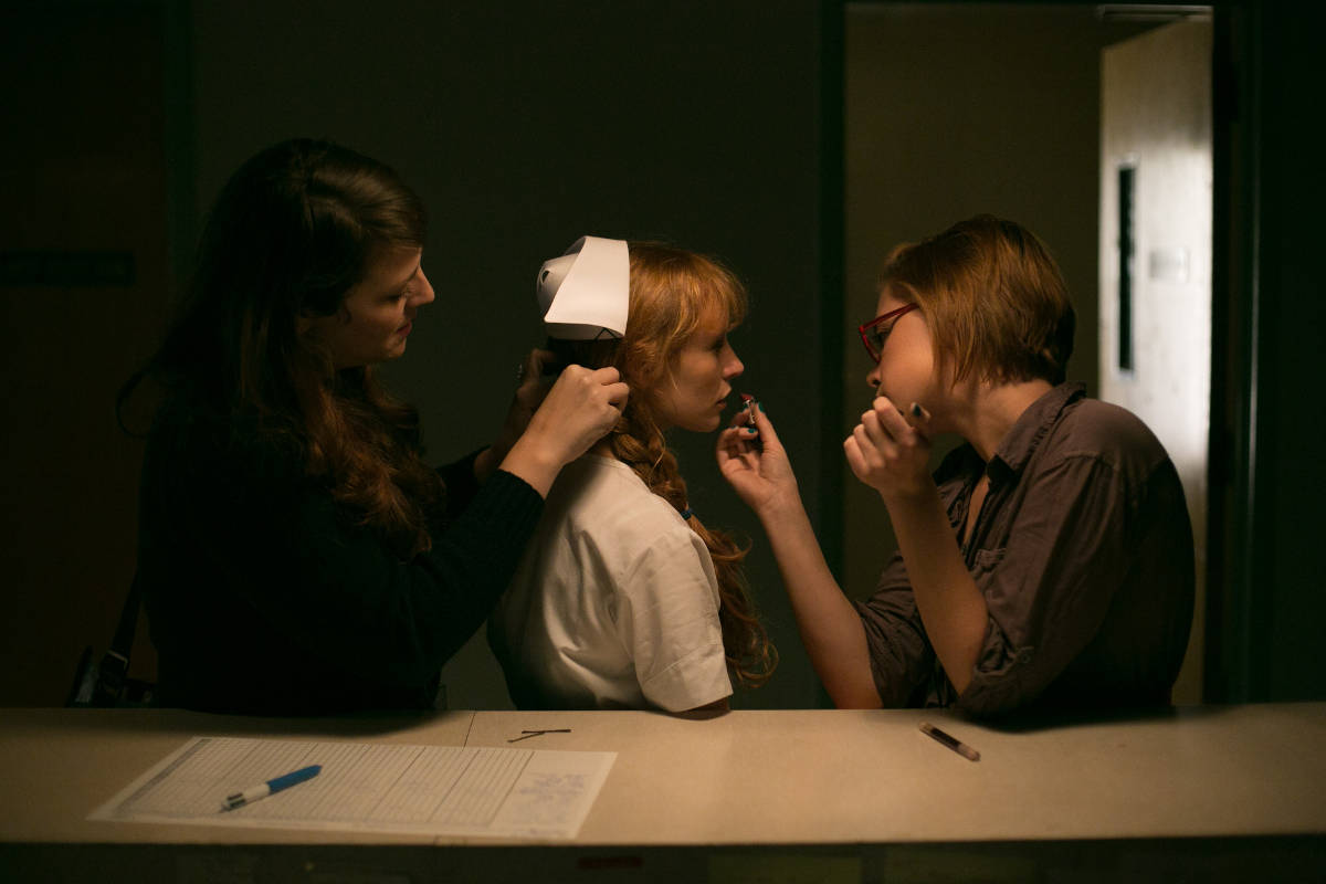 Lauren Bates Jaffe the head of the hair department and key makeup artist Sarah Patch touch up Stef Dawson's makeup prior to a take.